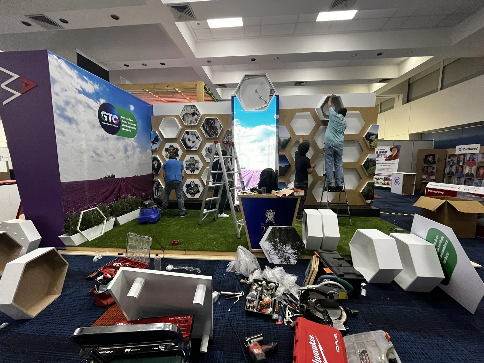 Crew installing hexagonal panels and lighting on the stand